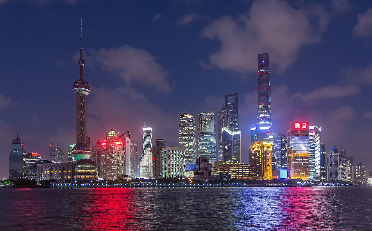 Shanghai's illuminated Pudong skyline across the Huangpu River at sunset